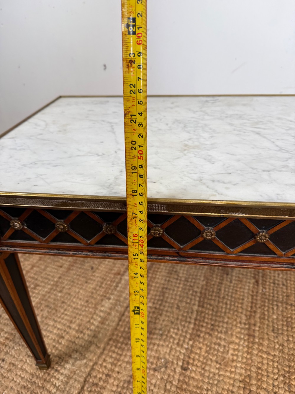 A rectangular Louis XVI style coffee table with a white marble top, dark wood lattice frieze, metal mounts, and tapered square legs. View XI