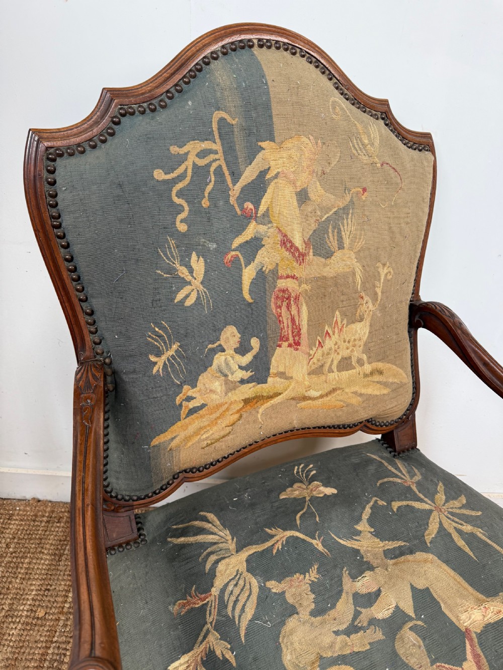 A late 19th-century open armchair with a carved walnut frame, cabriole legs, and muted green tapestry upholstery featuring pictorial motifs. View III