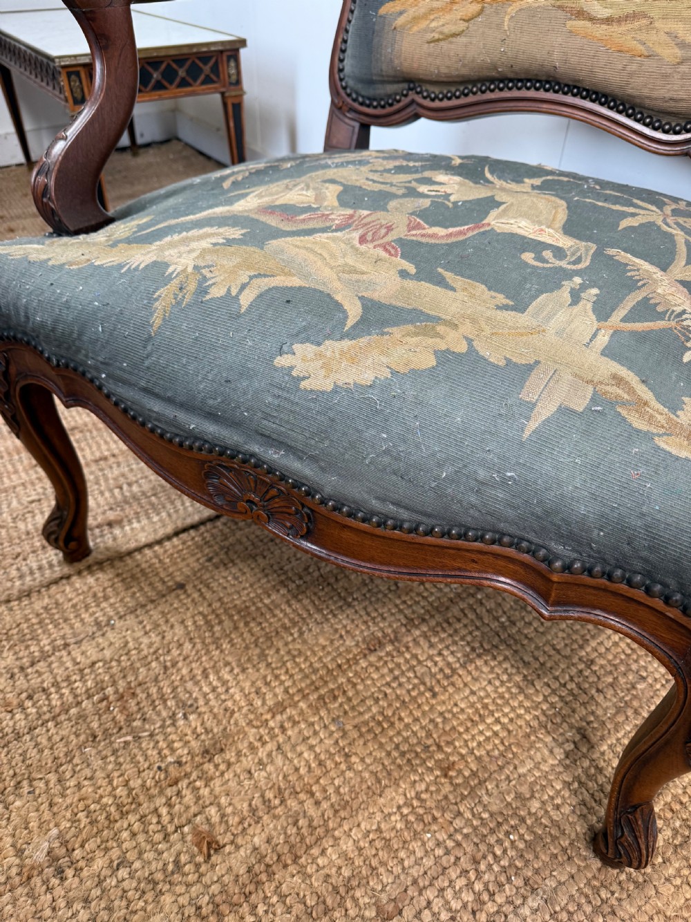 A late 19th-century open armchair with a carved walnut frame, cabriole legs, and muted green tapestry upholstery featuring pictorial motifs. View VIII