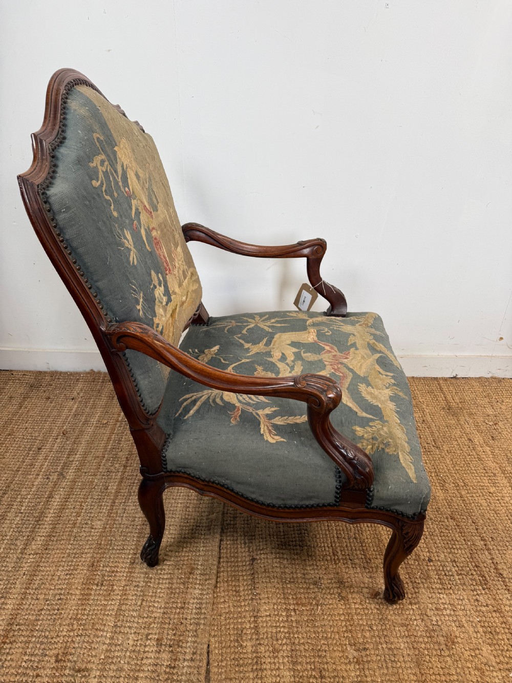 A late 19th-century open armchair with a carved walnut frame, cabriole legs, and muted green tapestry upholstery featuring pictorial motifs. View IX