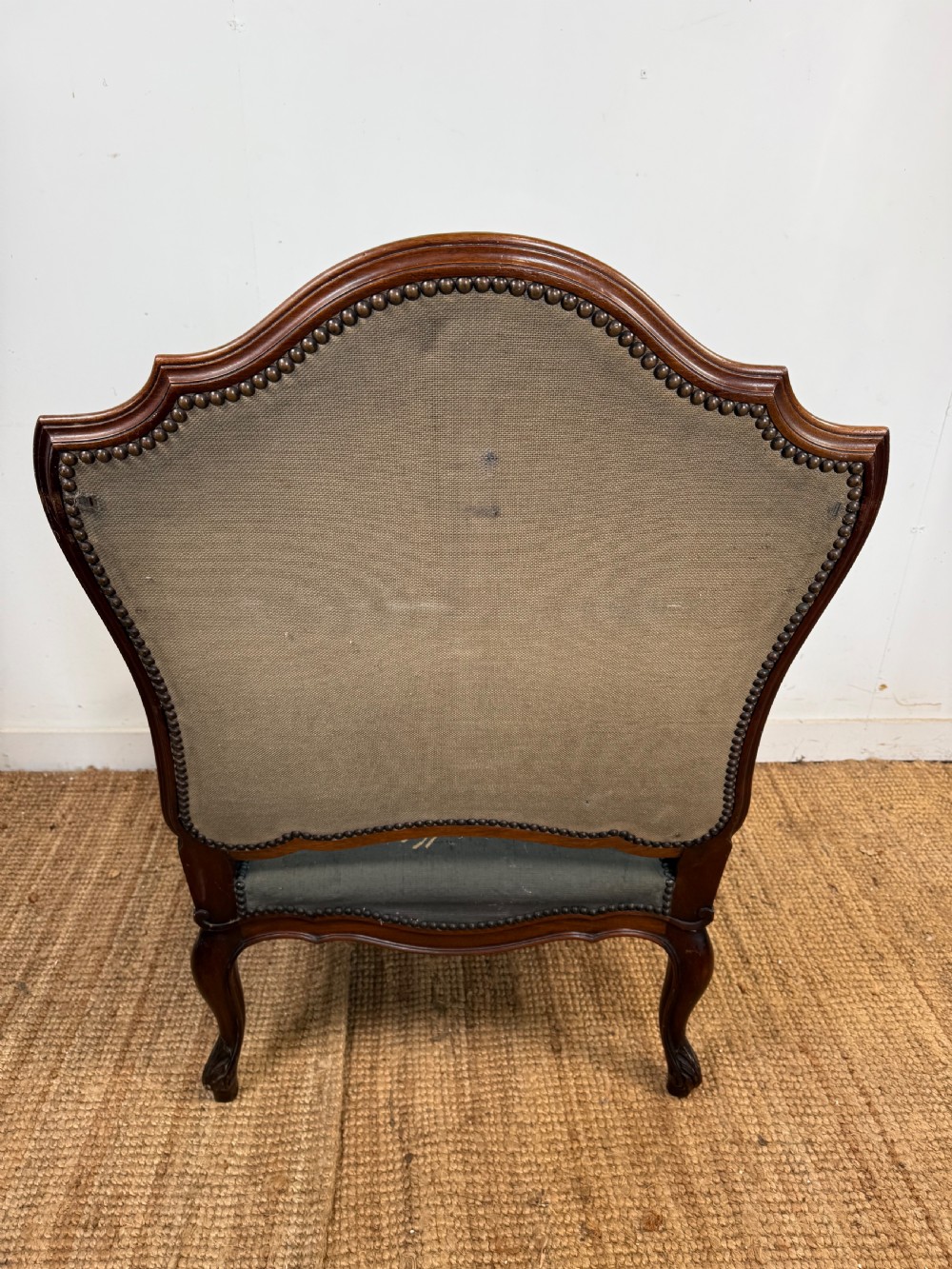 A late 19th-century open armchair with a carved walnut frame, cabriole legs, and muted green tapestry upholstery featuring pictorial motifs. View X