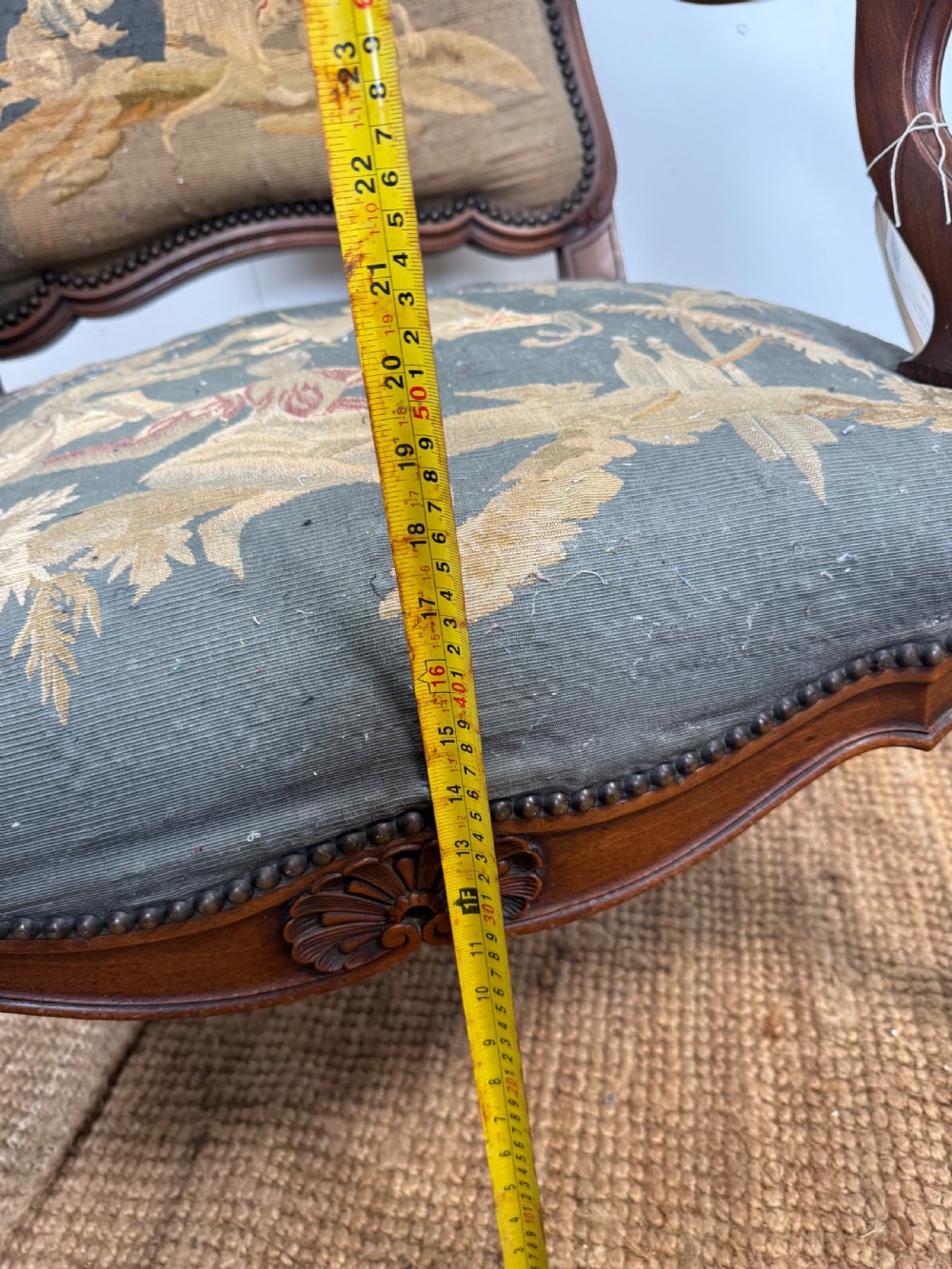 A late 19th-century open armchair with a carved walnut frame, cabriole legs, and muted green tapestry upholstery featuring pictorial motifs. View XVI