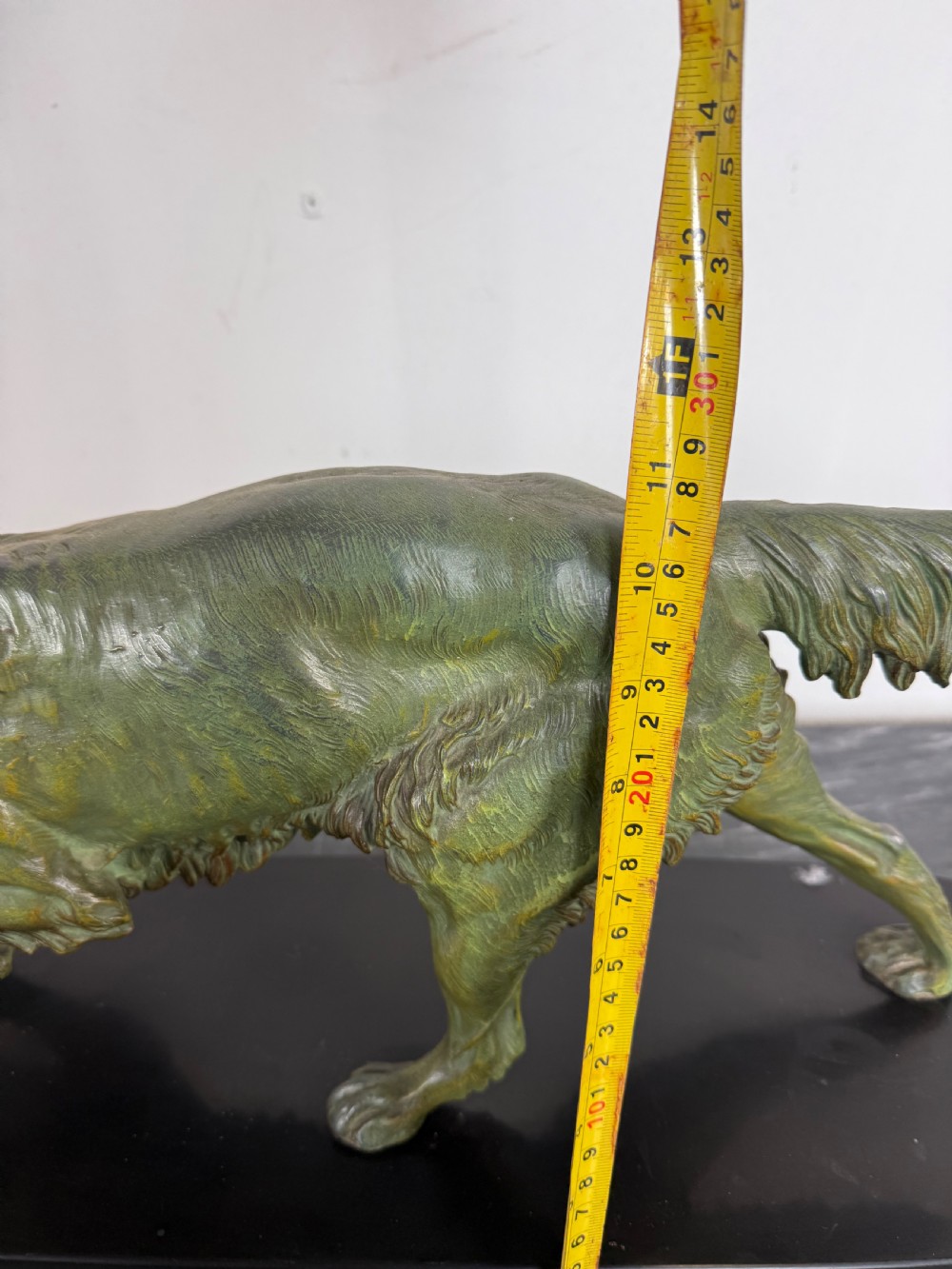 An Art Deco spelter sculpture depicting a prowling hunting dog with a green verdigris patina finish, mounted on an oval black marble base. View XII