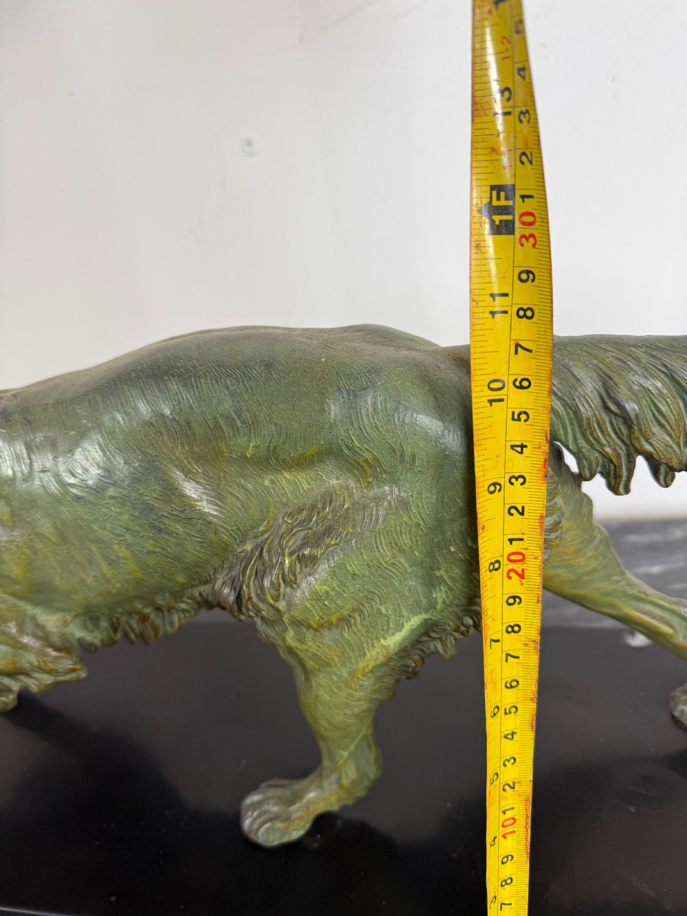 An Art Deco spelter sculpture depicting a prowling hunting dog with a green verdigris patina finish, mounted on an oval black marble base. View XIII