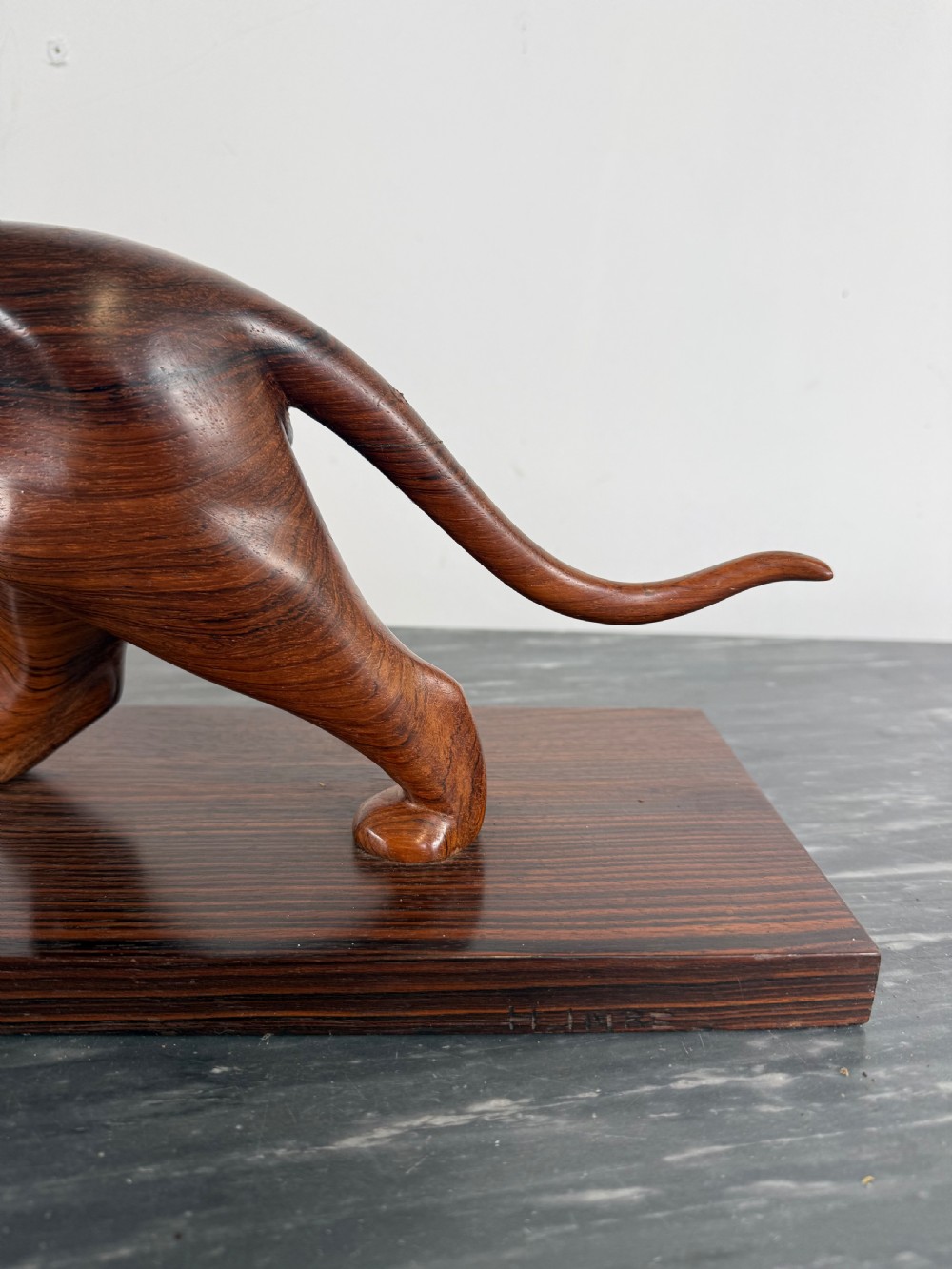 A carved dark wood Art Deco sculpture depicting a prowling panther mounted on a matching rectangular timber base. View V