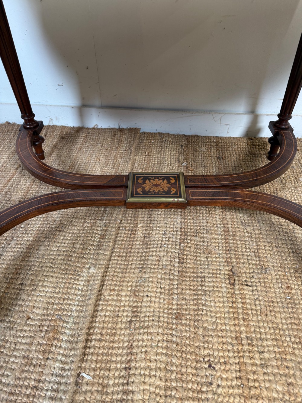 A French Napoleon III period centre table featuring floral wood marquetry, brass edges, tapered fluted legs, and an arched lower stretcher. View VI