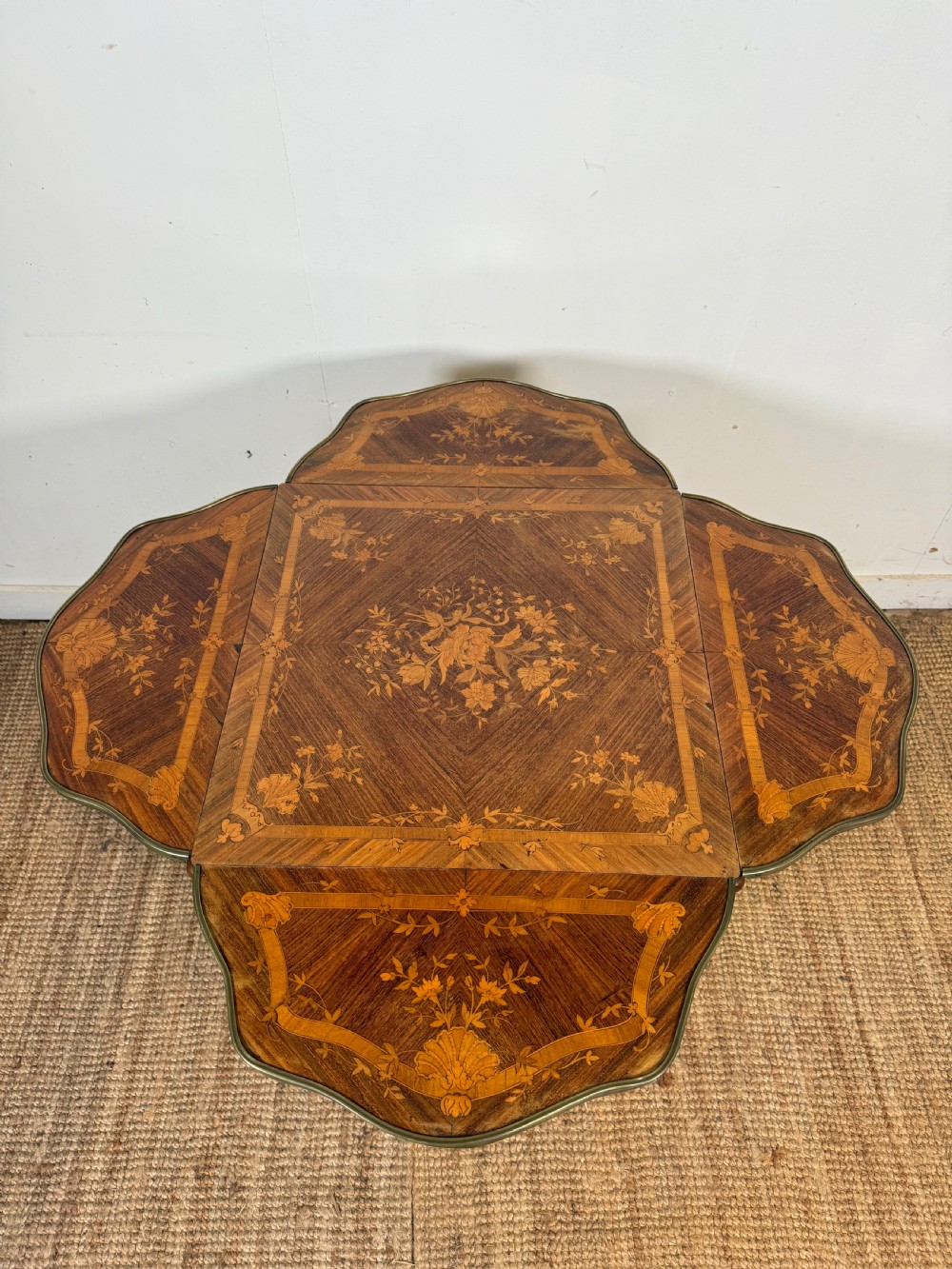 A French Napoleon III rosewood side table featuring floral marquetry inlays, drop leaves, and curved cabriole legs with brass mounts. View V