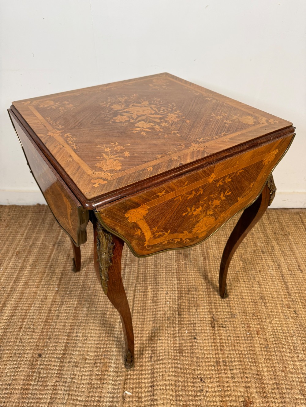 A French Napoleon III rosewood side table featuring floral marquetry inlays, drop leaves, and curved cabriole legs with brass mounts. View XI