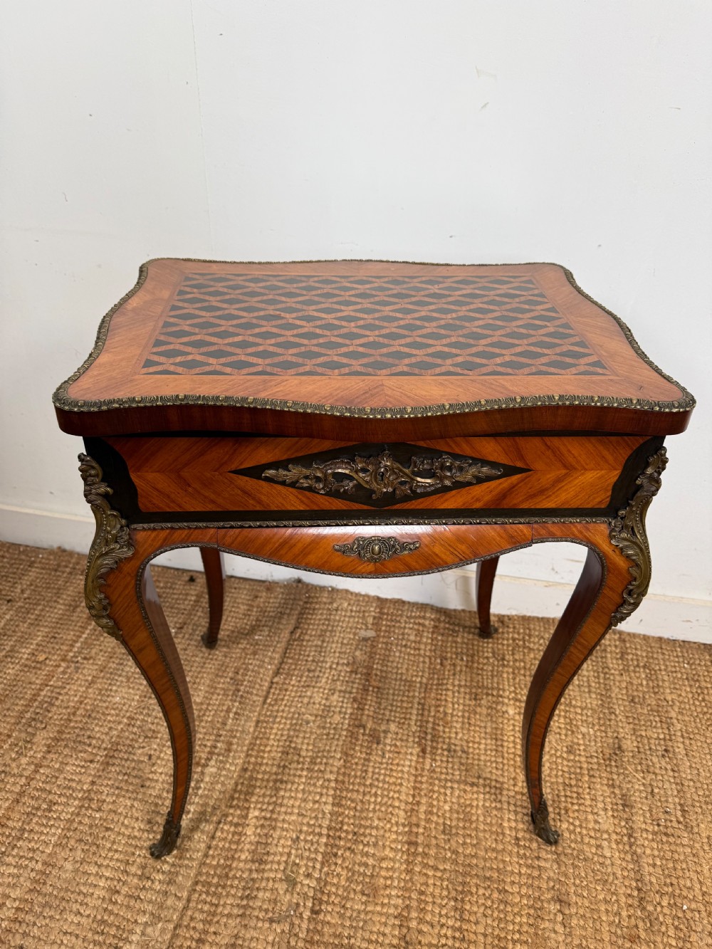 A 19th-century French Napoleon III work table with diamond geometric parquetry, gilt bronze mounts, and cabriole legs.
