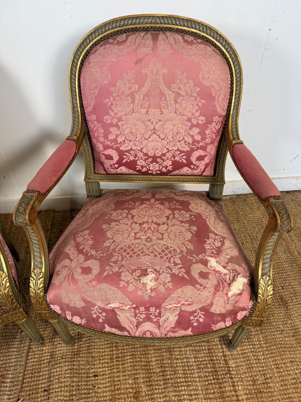 A pair of Louis XVI style French open armchairs featuring carved giltwood frames, fluted legs, and pink damask pattern upholstery. View VI