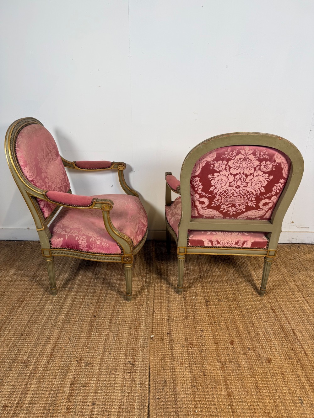 A pair of Louis XVI style French open armchairs featuring carved giltwood frames, fluted legs, and pink damask pattern upholstery. View IX