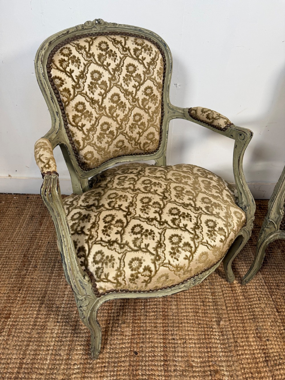 A pair of late 19th-century French style open armchairs with carved muted green painted frames and patterned velvet fabric. View II