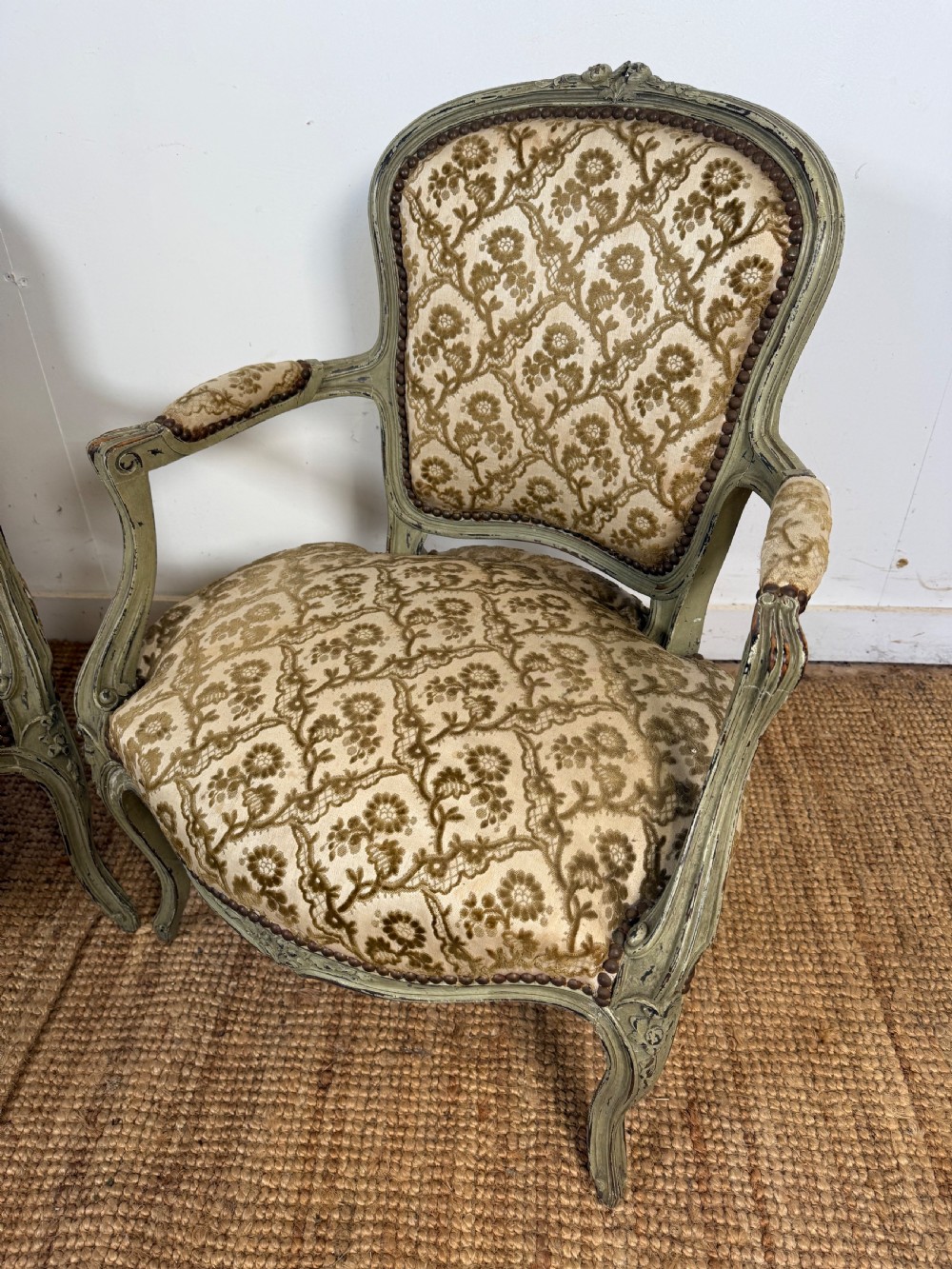A pair of late 19th-century French style open armchairs with carved muted green painted frames and patterned velvet fabric. View V