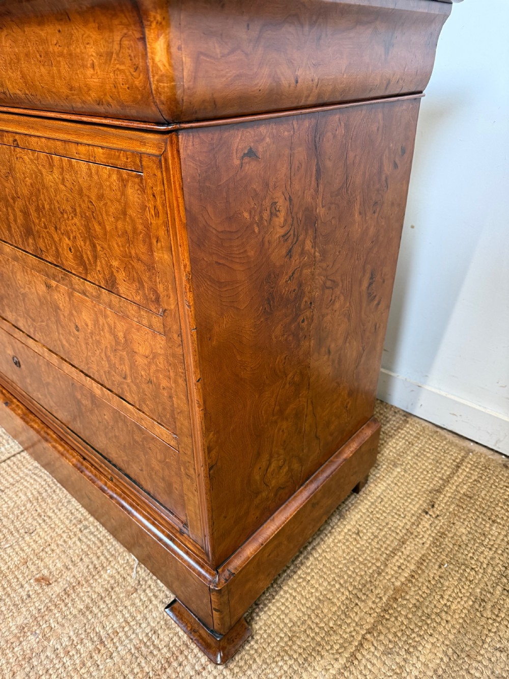 A rectangular 19th-century burr elm commode featuring a grey mottled marble top and three long drawers with central key escutcheons. View X