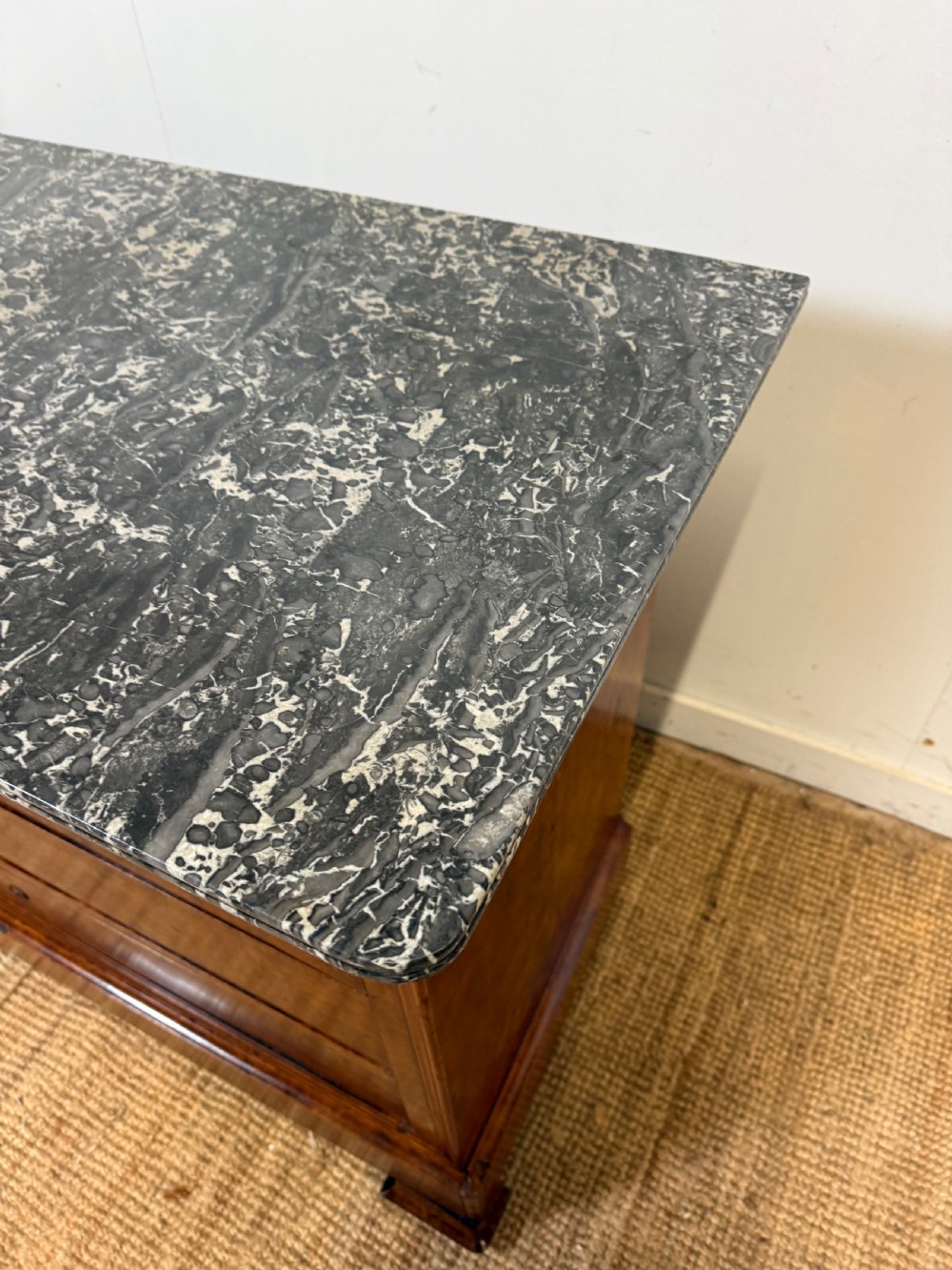A rectangular 19th-century burr elm commode featuring a grey mottled marble top and three long drawers with central key escutcheons. View XII