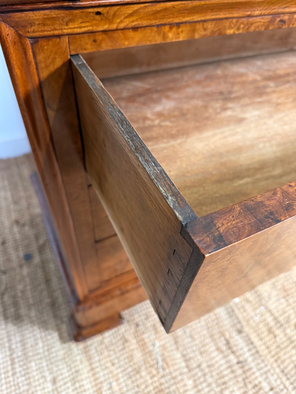 A rectangular 19th-century burr elm commode featuring a grey mottled marble top and three long drawers with central key escutcheons. View XIV