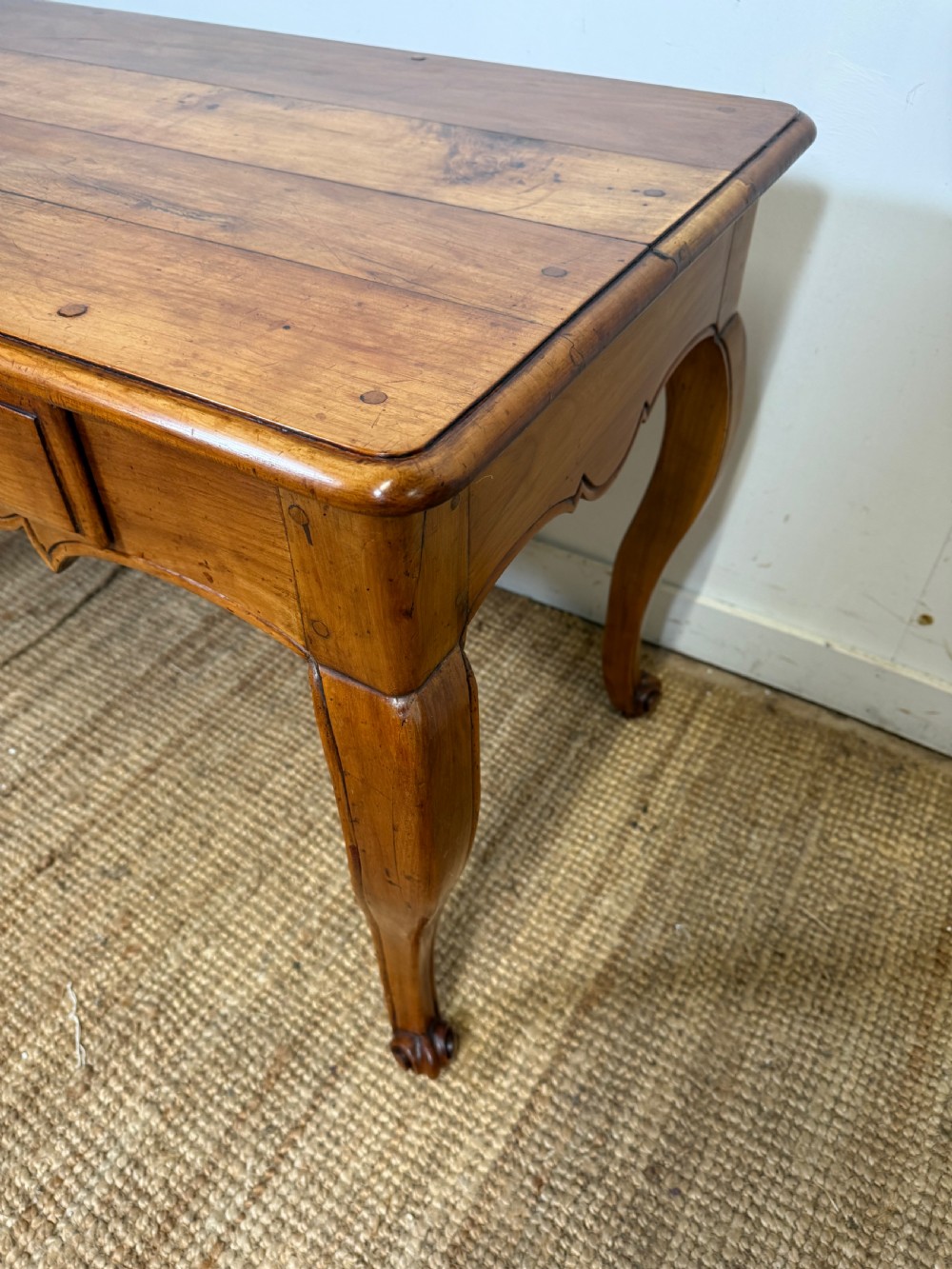 An early nineteenth-century French cherrywood side table featuring cabriole legs, a contoured apron with a single drawer, and a warm honey-coloured timber finish. View VII
