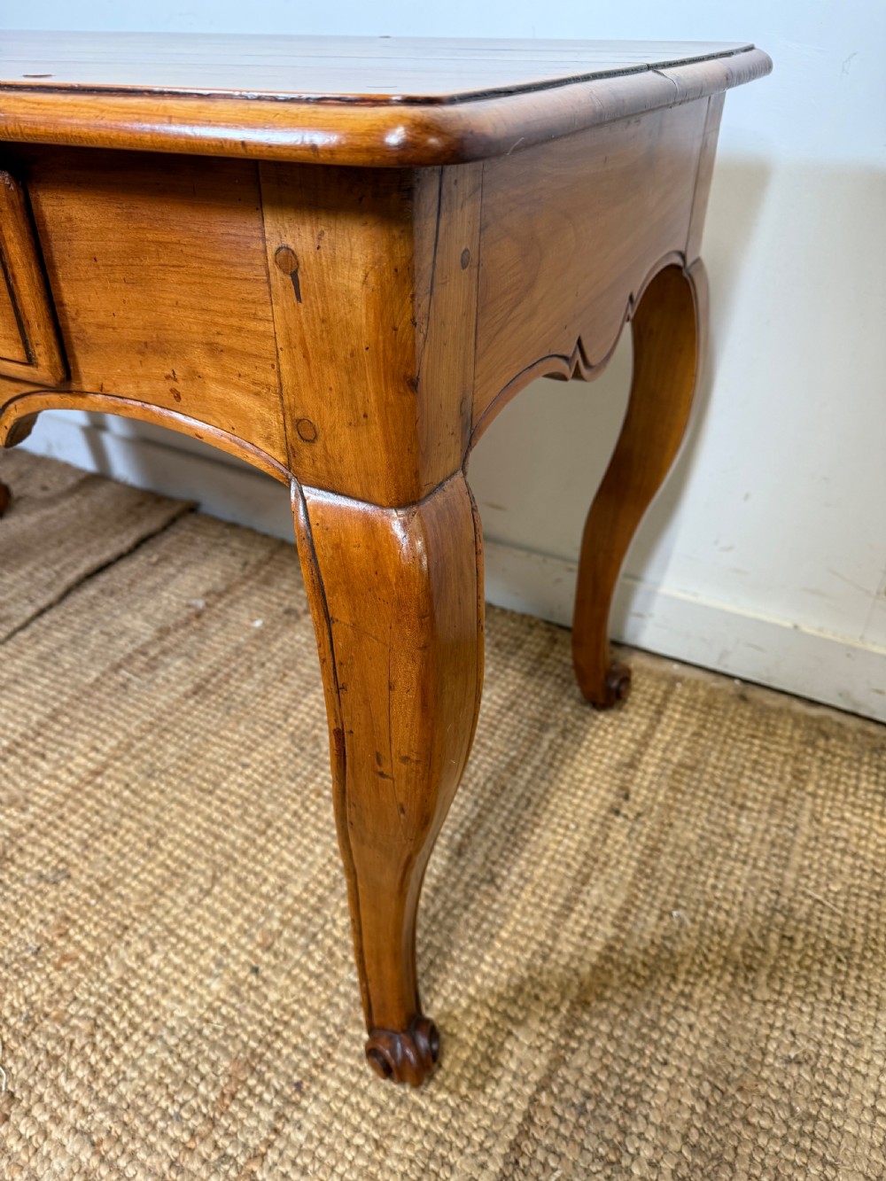 An early nineteenth-century French cherrywood side table featuring cabriole legs, a contoured apron with a single drawer, and a warm honey-coloured timber finish. View VIII