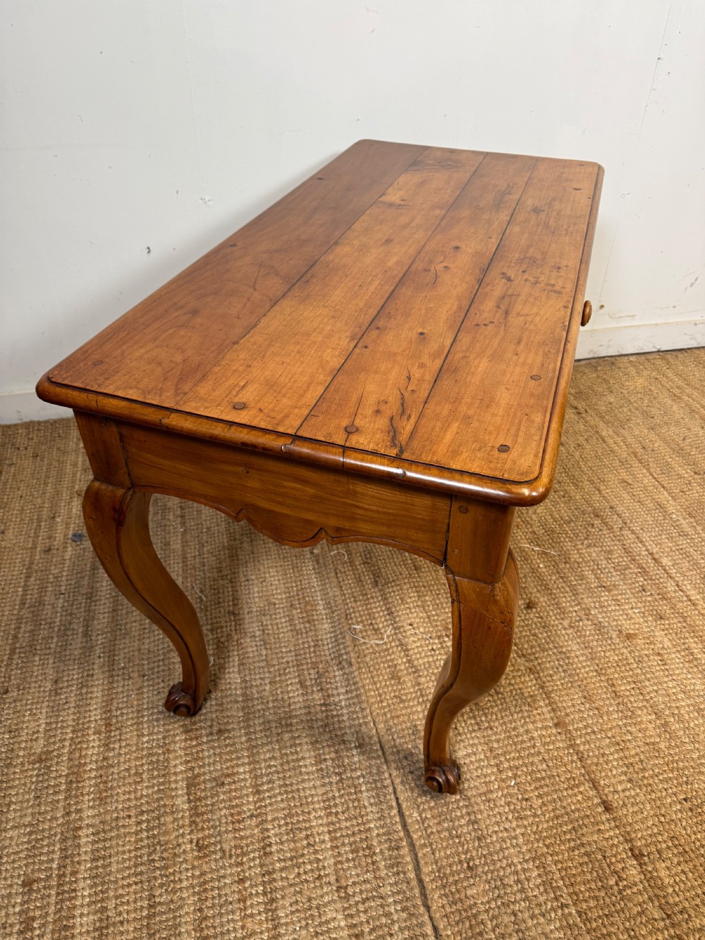 An early nineteenth-century French cherrywood side table featuring cabriole legs, a contoured apron with a single drawer, and a warm honey-coloured timber finish. View IX