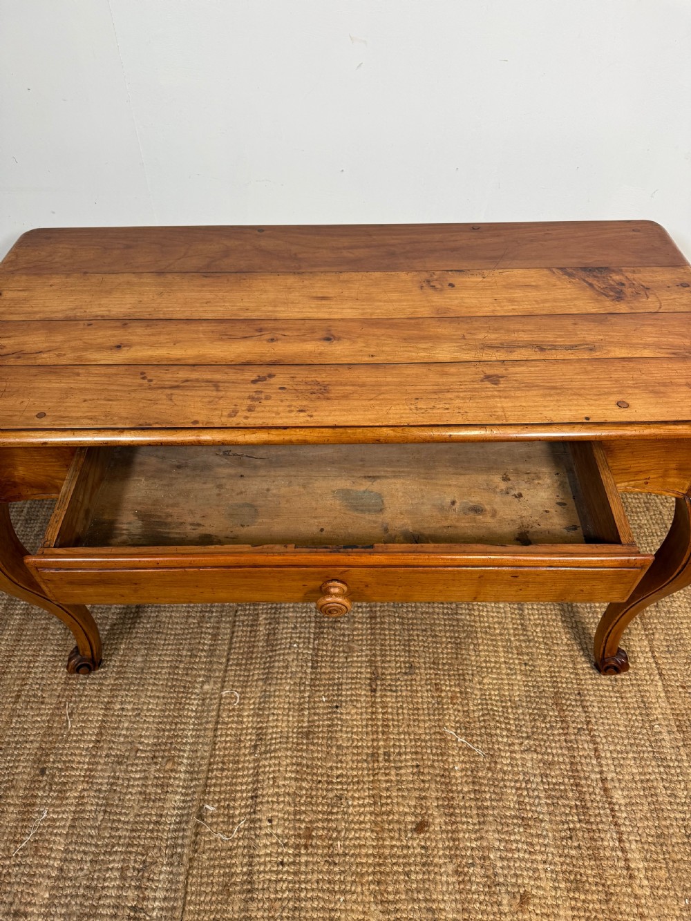 An early nineteenth-century French cherrywood side table featuring cabriole legs, a contoured apron with a single drawer, and a warm honey-coloured timber finish. View XII
