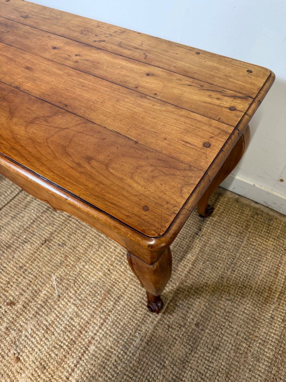 An early nineteenth-century French cherrywood side table featuring cabriole legs, a contoured apron with a single drawer, and a warm honey-coloured timber finish. View XVII
