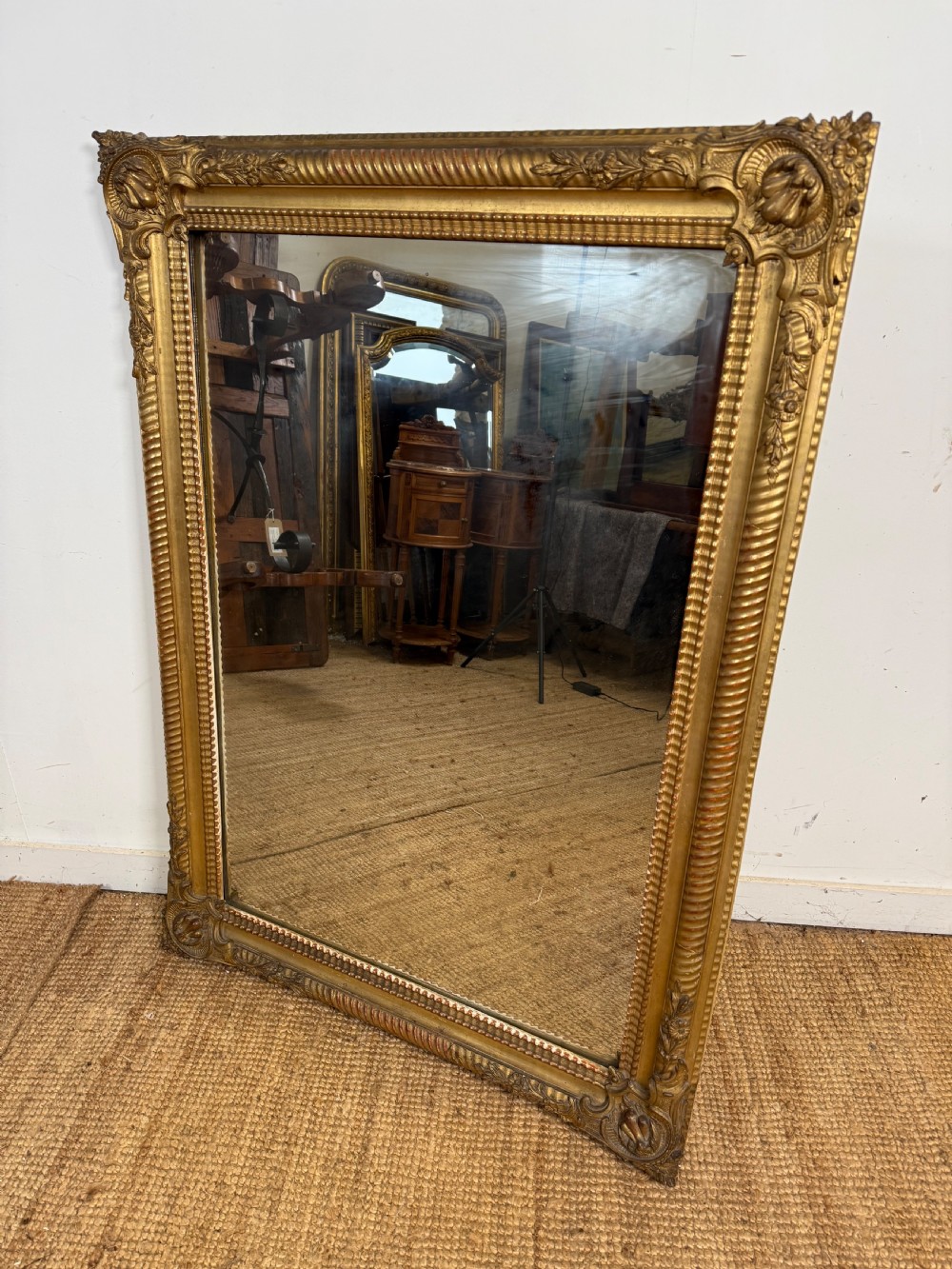 A large rectangular 19th-century French wall mirror featuring a gold leaf gesso frame with rope twist borders and decorative corner flourishes.