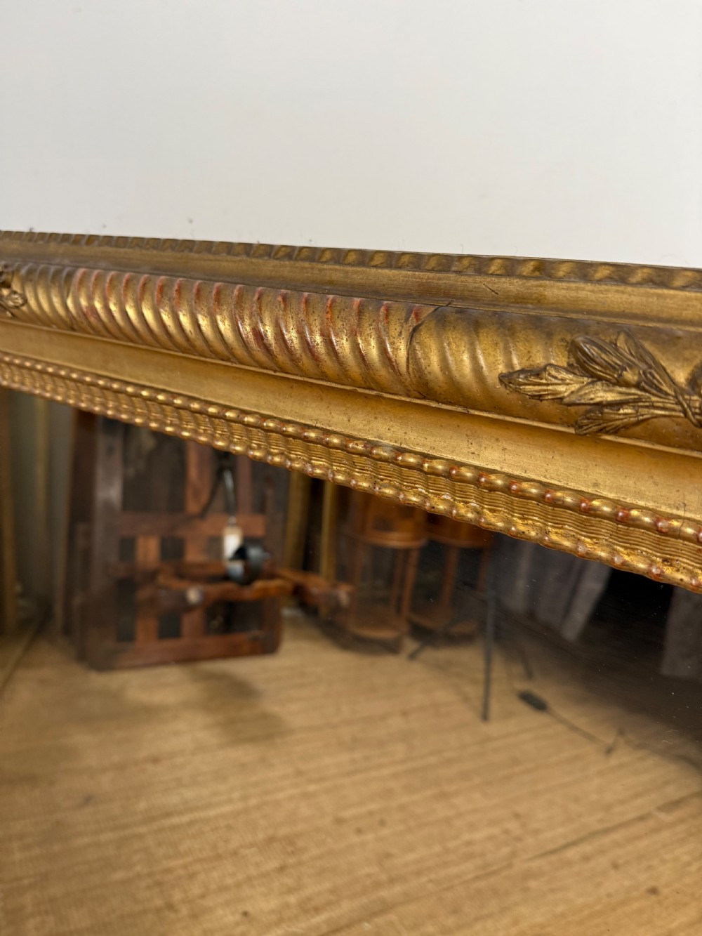 A large rectangular 19th-century French wall mirror featuring a gold leaf gesso frame with rope twist borders and decorative corner flourishes. View VI