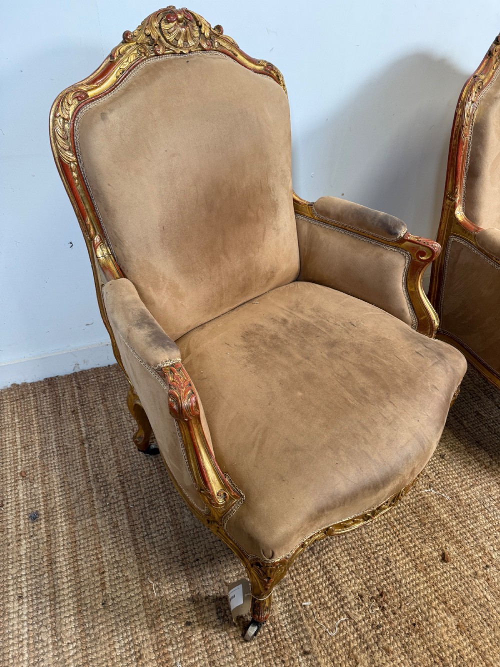 A pair of 19th-century French Napoleon III giltwood armchairs upholstered in taupe velvet with carved floral crests and cabriole legs. View II