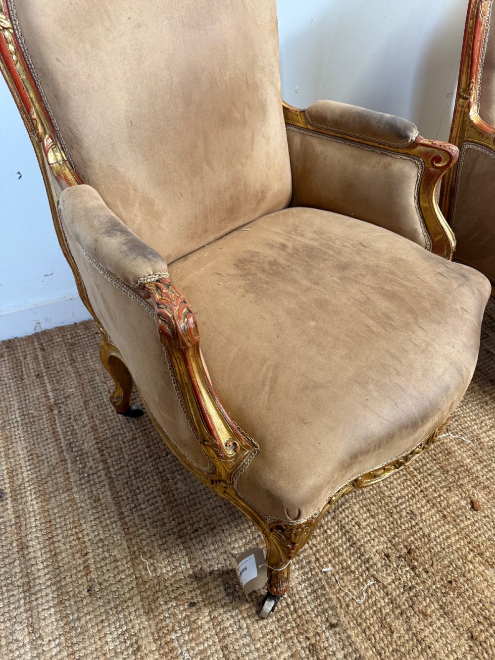 A pair of 19th-century French Napoleon III giltwood armchairs upholstered in taupe velvet with carved floral crests and cabriole legs. View V