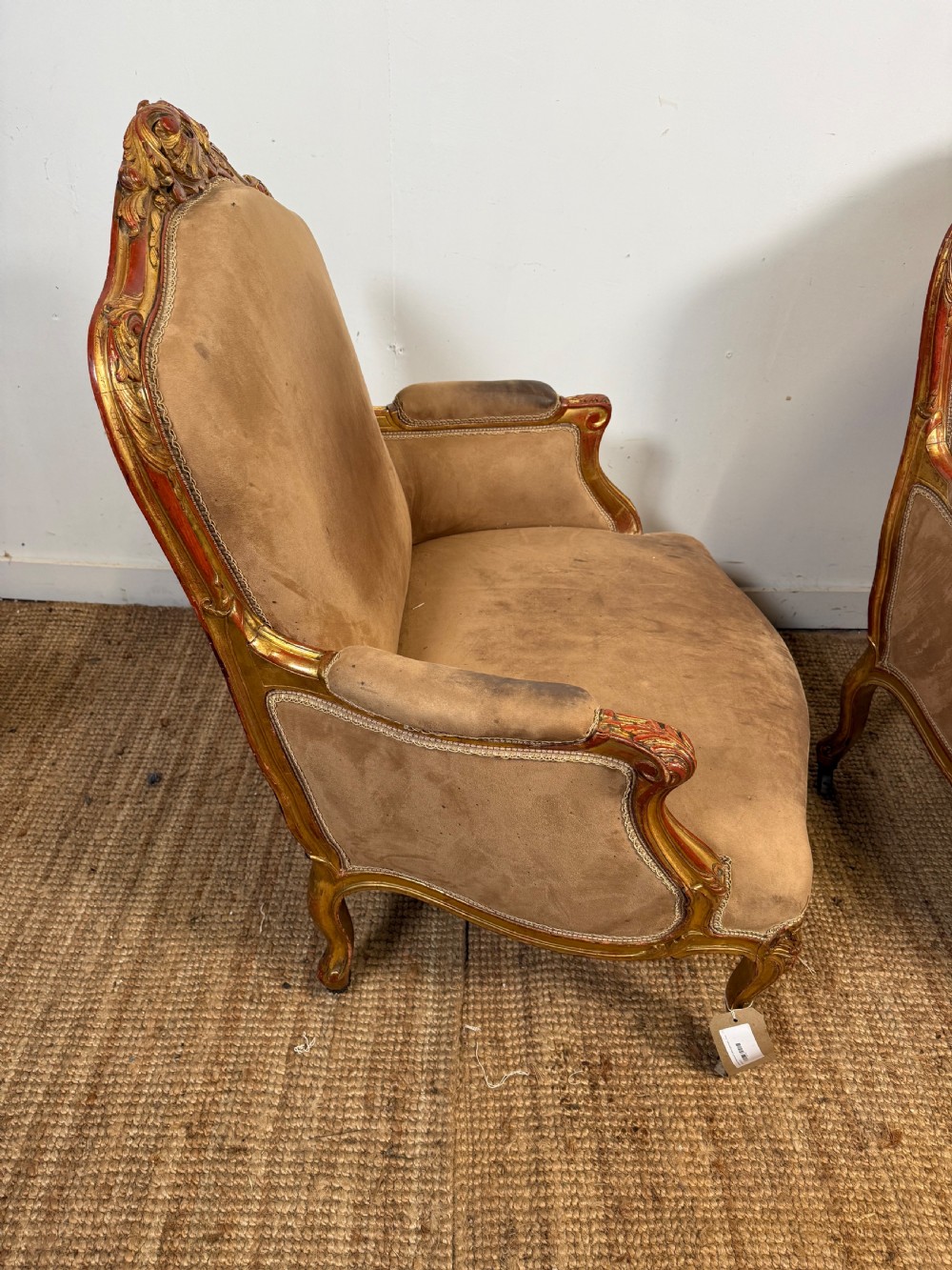 A pair of 19th-century French Napoleon III giltwood armchairs upholstered in taupe velvet with carved floral crests and cabriole legs. View X
