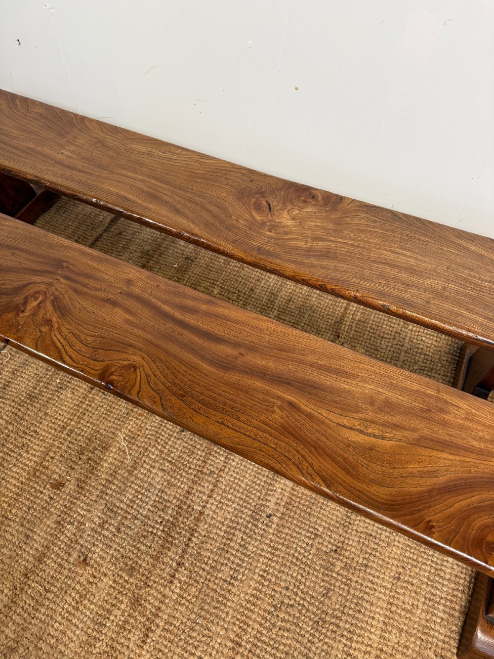A pair of early 20th-century French rustic benches crafted from solid warm brown elm with visible wood grain and trestle end supports. View III