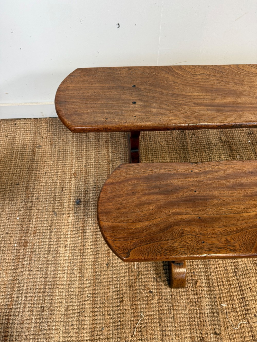 A pair of early 20th-century French rustic benches crafted from solid warm brown elm with visible wood grain and trestle end supports. View VII