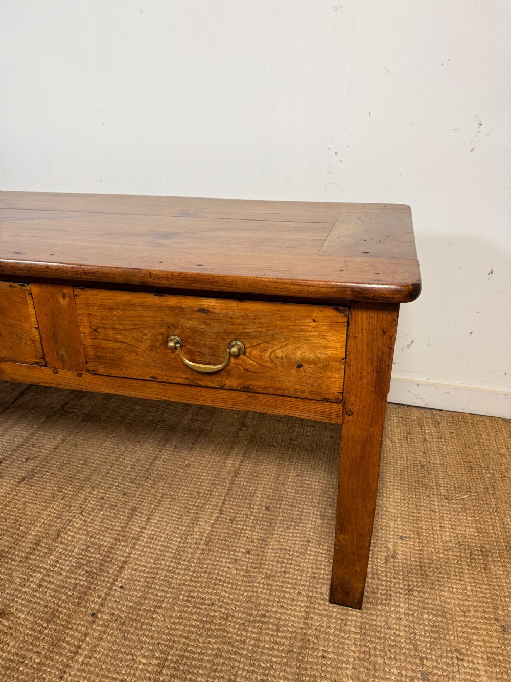 A 19th-century French provincial wooden dresser base featuring three drawers with brass bail handles set on straight legs. View III
