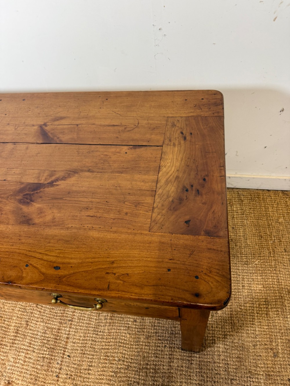 A 19th-century French provincial wooden dresser base featuring three drawers with brass bail handles set on straight legs. View IV