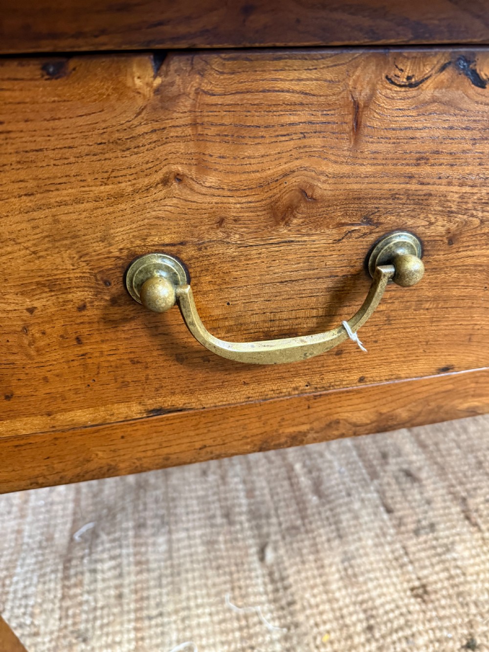 A 19th-century French provincial wooden dresser base featuring three drawers with brass bail handles set on straight legs. View X