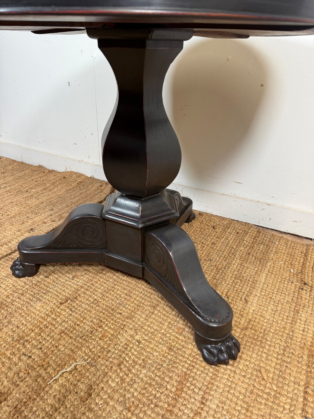 A 19th-century French circular gueridon side table featuring a dark speckled marble top, black painted pedestal support, and scroll feet. View IV