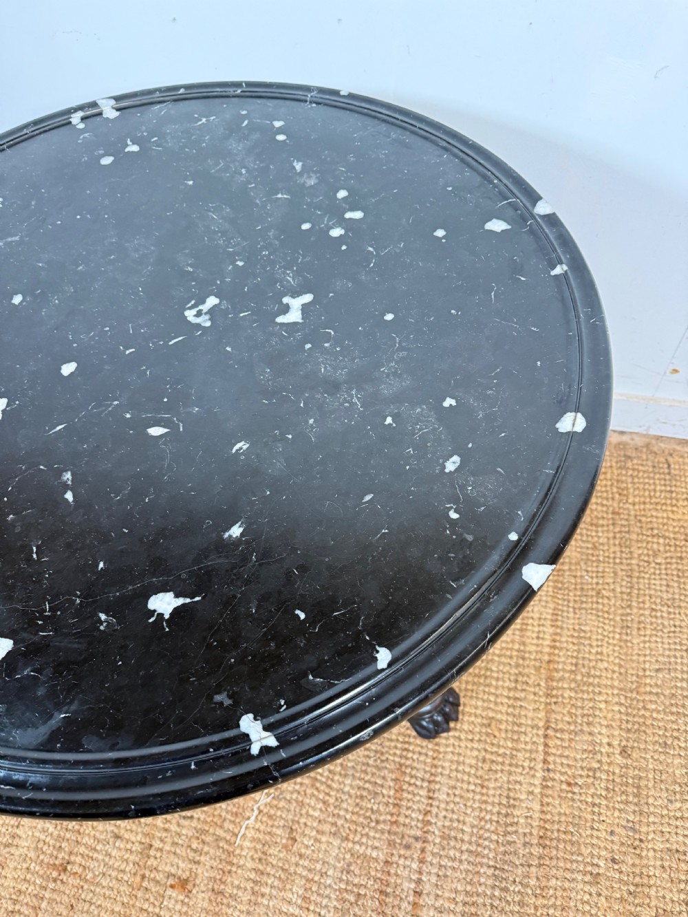 A 19th-century French circular gueridon side table featuring a dark speckled marble top, black painted pedestal support, and scroll feet. View VI