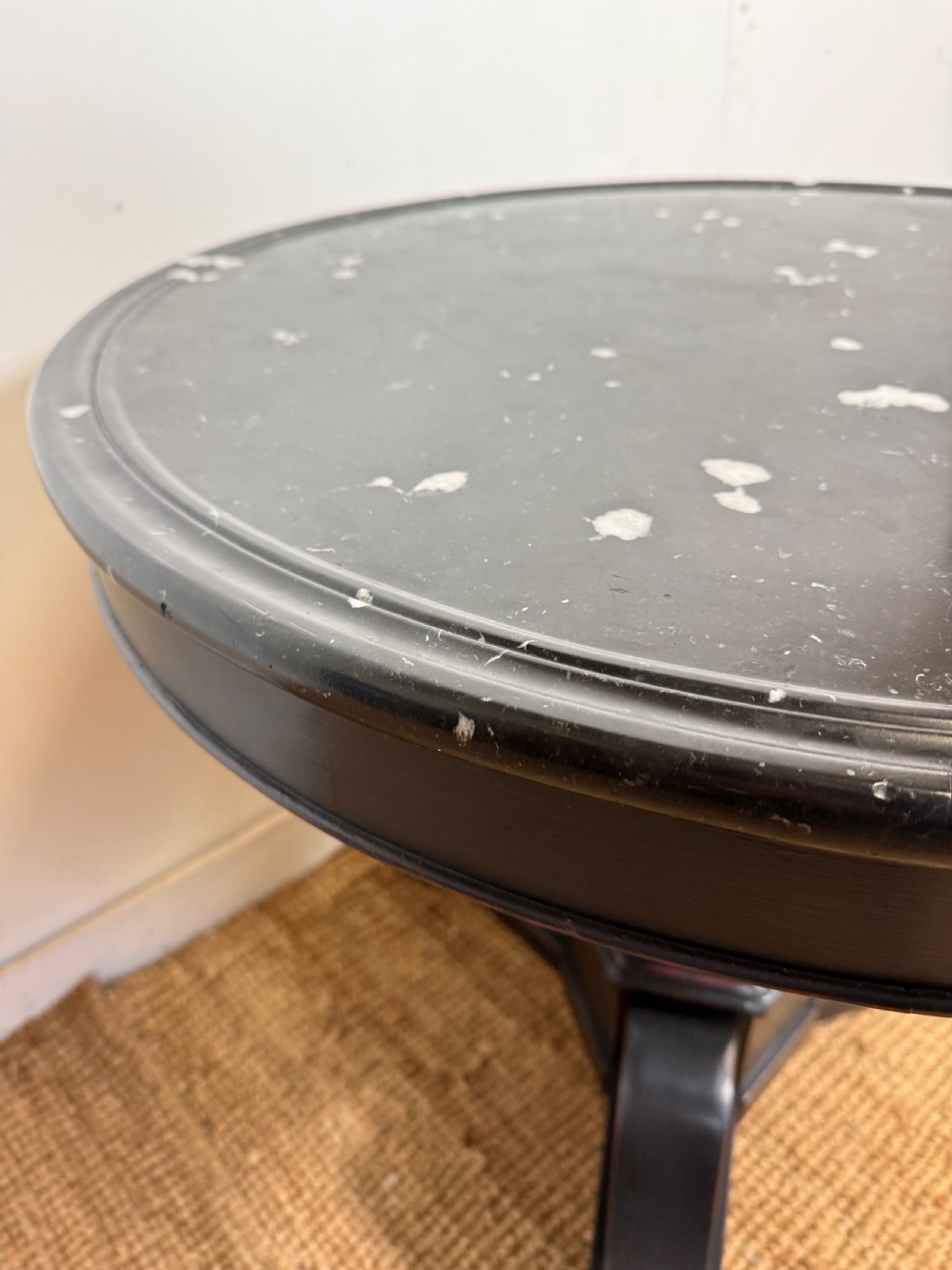 A 19th-century French circular gueridon side table featuring a dark speckled marble top, black painted pedestal support, and scroll feet. View VIII