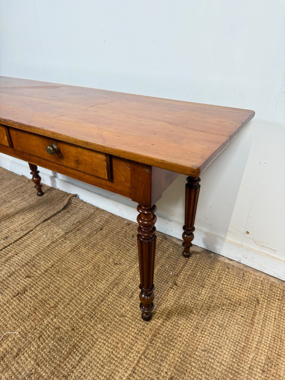 A 19th-century French cherrywood console table featuring two frieze drawers with brass knobs and four turned, fluted legs. View II