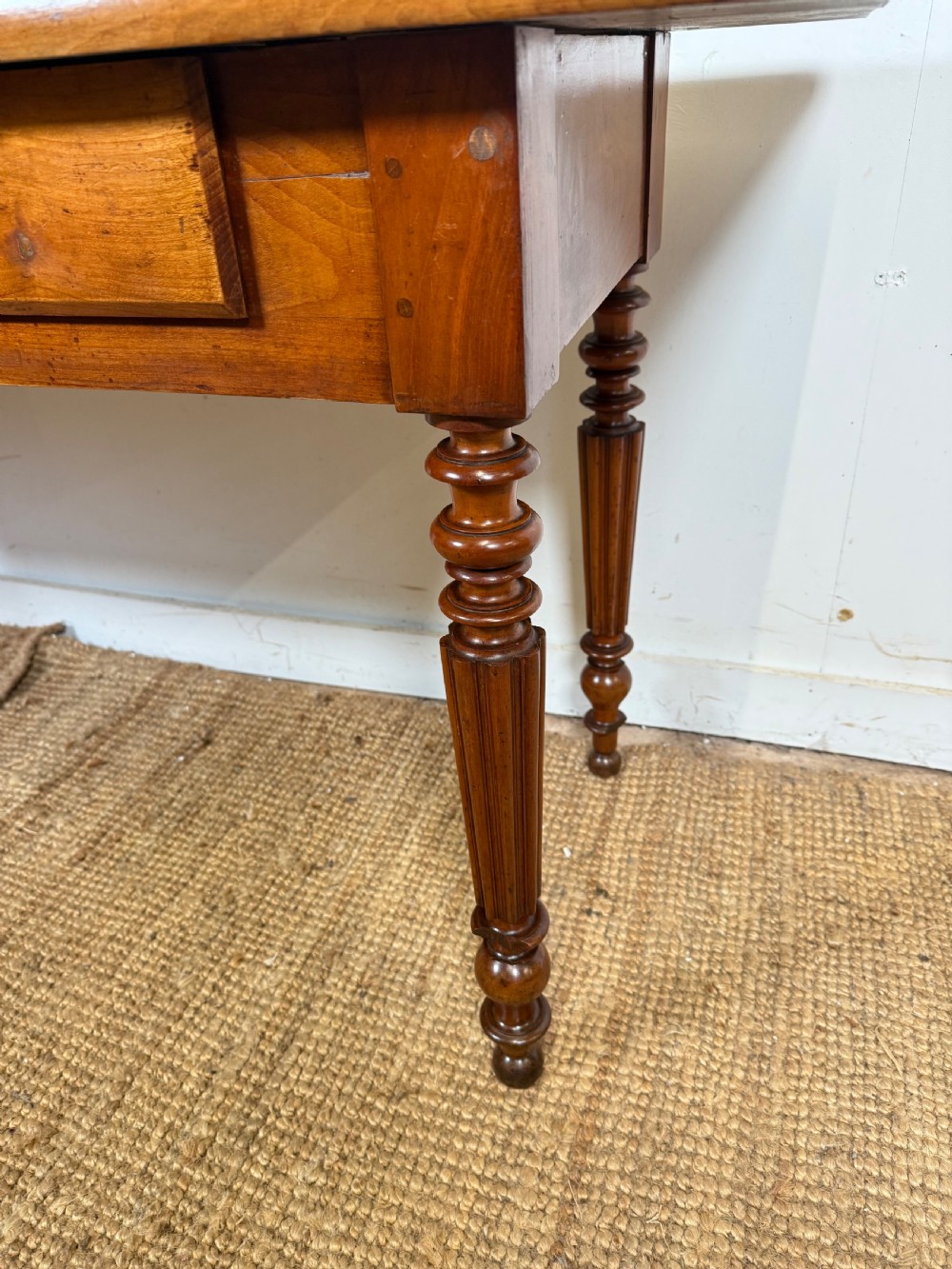 A 19th-century French cherrywood console table featuring two frieze drawers with brass knobs and four turned, fluted legs. View III