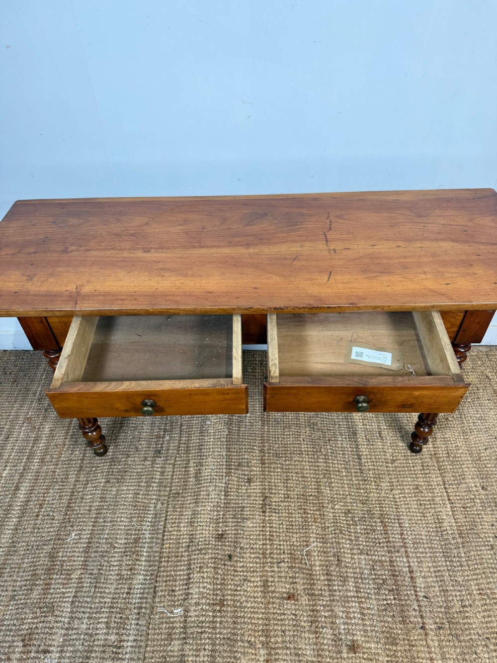 A 19th-century French cherrywood console table featuring two frieze drawers with brass knobs and four turned, fluted legs. View V