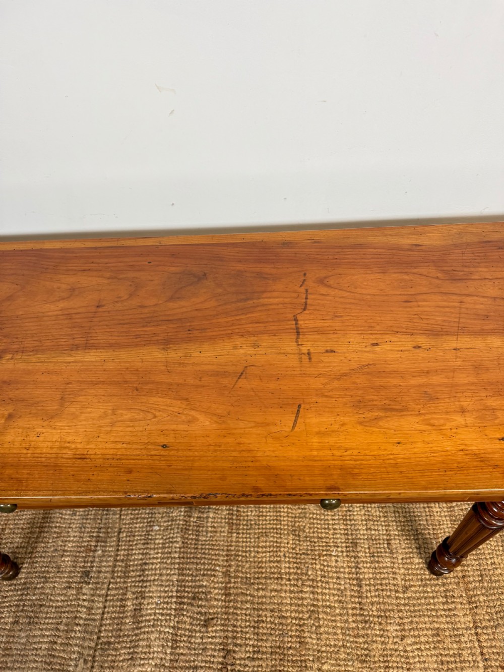 A 19th-century French cherrywood console table featuring two frieze drawers with brass knobs and four turned, fluted legs. View VII