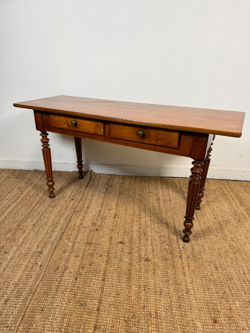 A 19th-century French cherrywood console table featuring two frieze drawers with brass knobs and four turned, fluted legs. View X