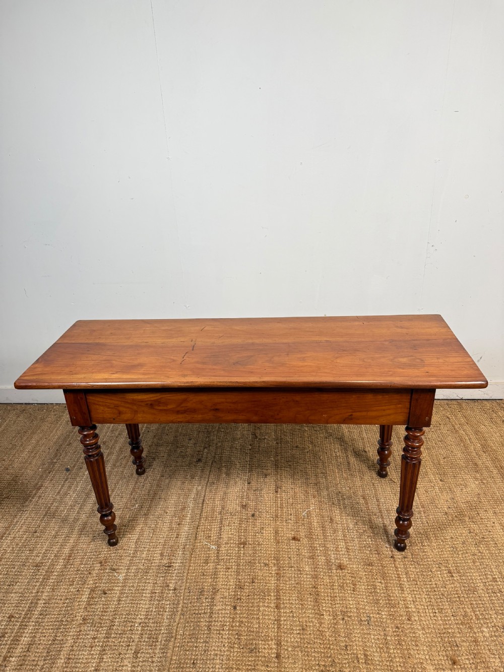 A 19th-century French cherrywood console table featuring two frieze drawers with brass knobs and four turned, fluted legs. View XI