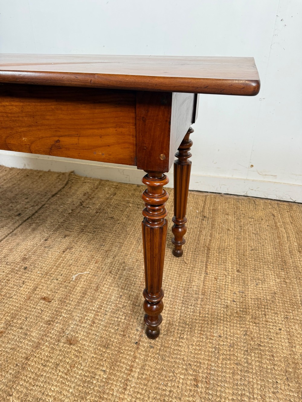 A 19th-century French cherrywood console table featuring two frieze drawers with brass knobs and four turned, fluted legs. View XII