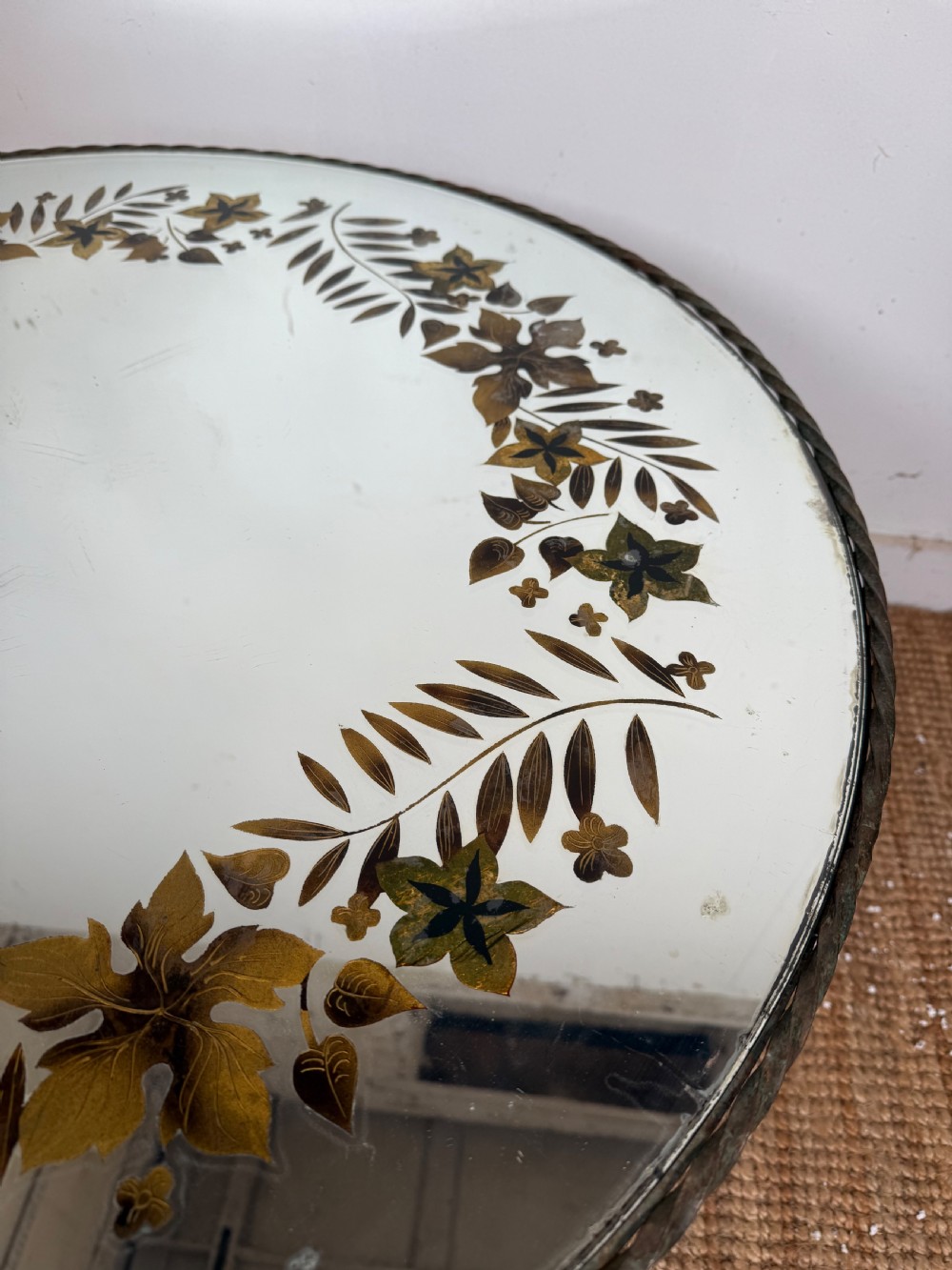 A round Art Deco coffee table featuring a verdigris wrought iron frame with scroll legs and a circular glass top decorated with a painted floral border. View IV