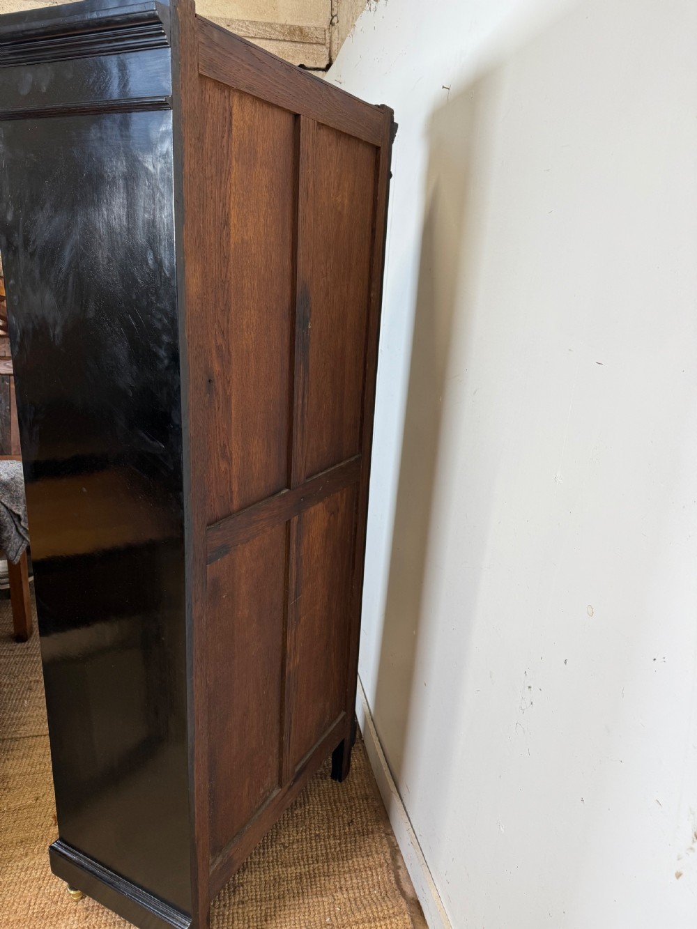 A narrow 19th-century Napoleon III ebonised wooden bookcase featuring a single glazed glass door, decorative gilt brass mounts, and a warm oak lined interior. View XIV