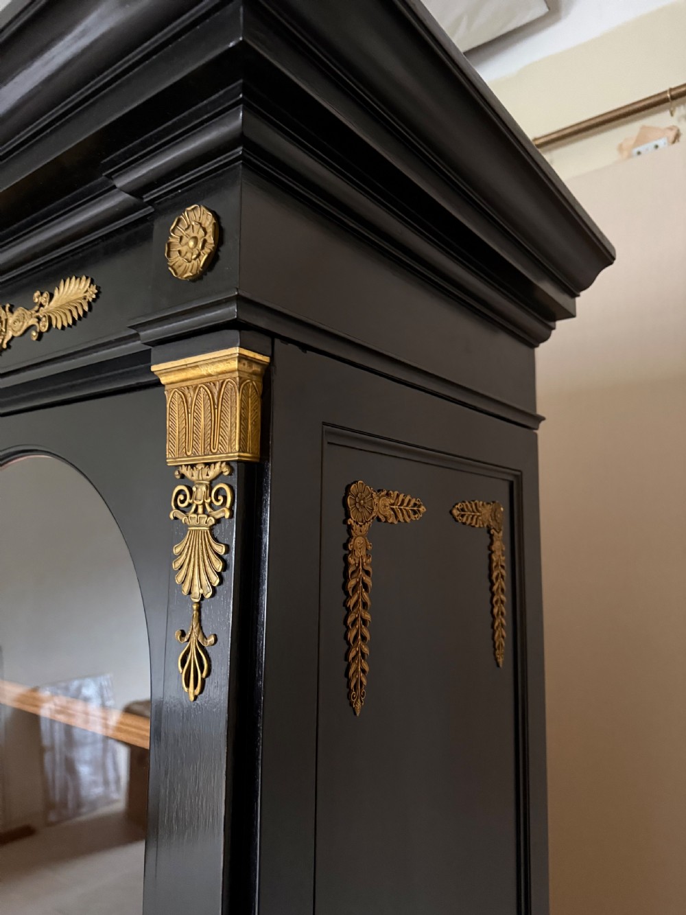 A large ebonised three-door glazed bookcase featuring gold-toned gilt-bronze mounts, arched glass panels, and an oak interior. View XI