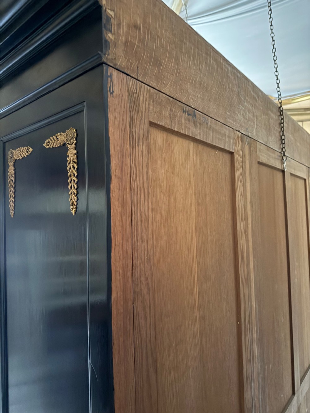 A large ebonised three-door glazed bookcase featuring gold-toned gilt-bronze mounts, arched glass panels, and an oak interior. View XII