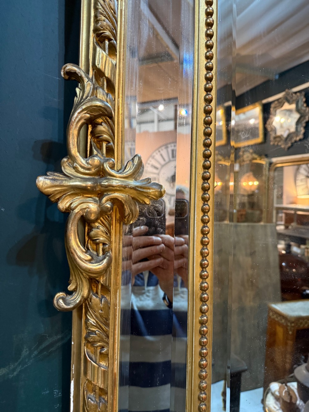 A 19th-century rectangular French giltwood wall mirror featuring elaborate cresting with cherubs, an urn finial, acanthus leaf scrolling, and a beaded inner border around a bevelled glass plate. View IV